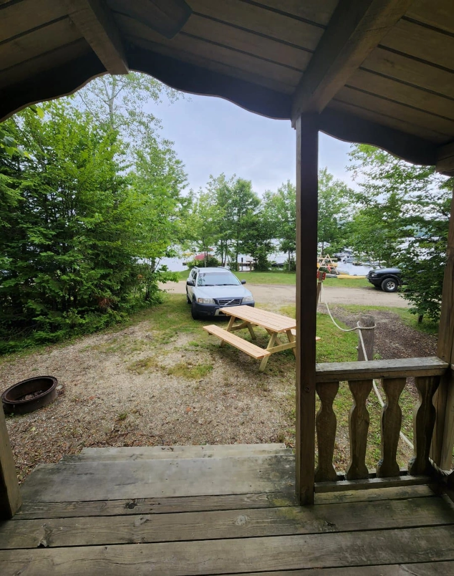 Car parked near picnic table in forest.