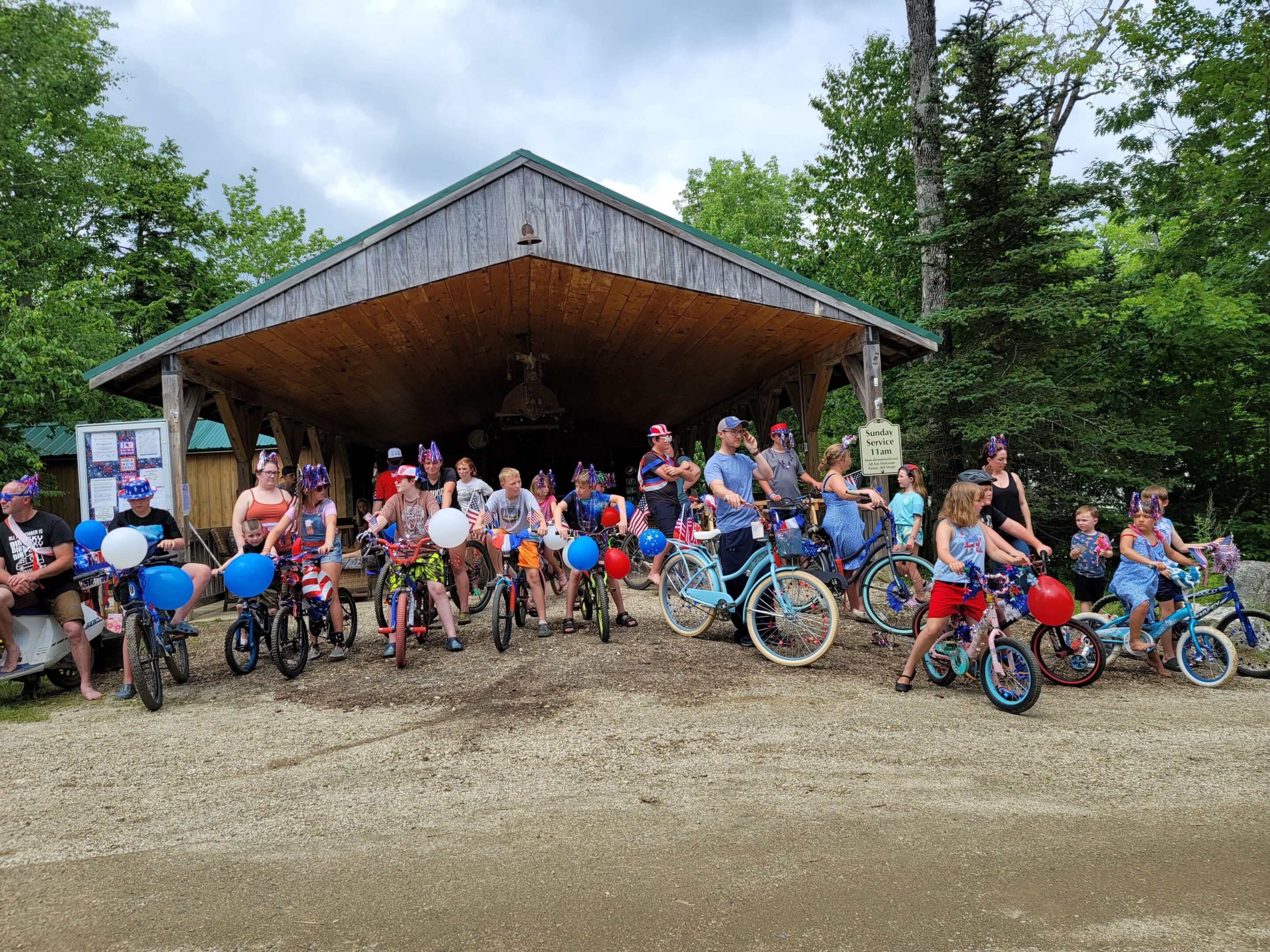 A group of people standing around bikes in front of a building.