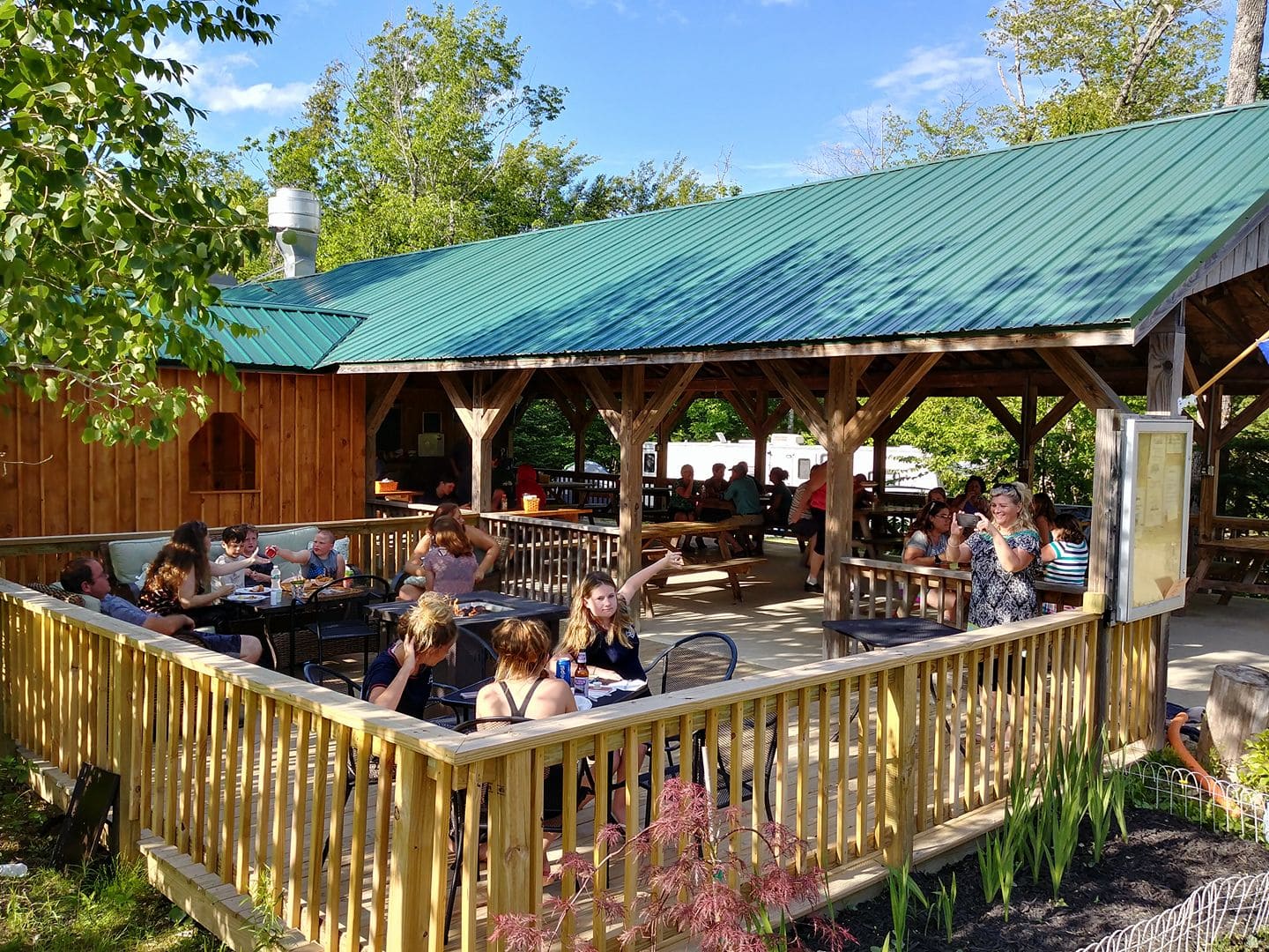 A group of people sitting at tables outside.