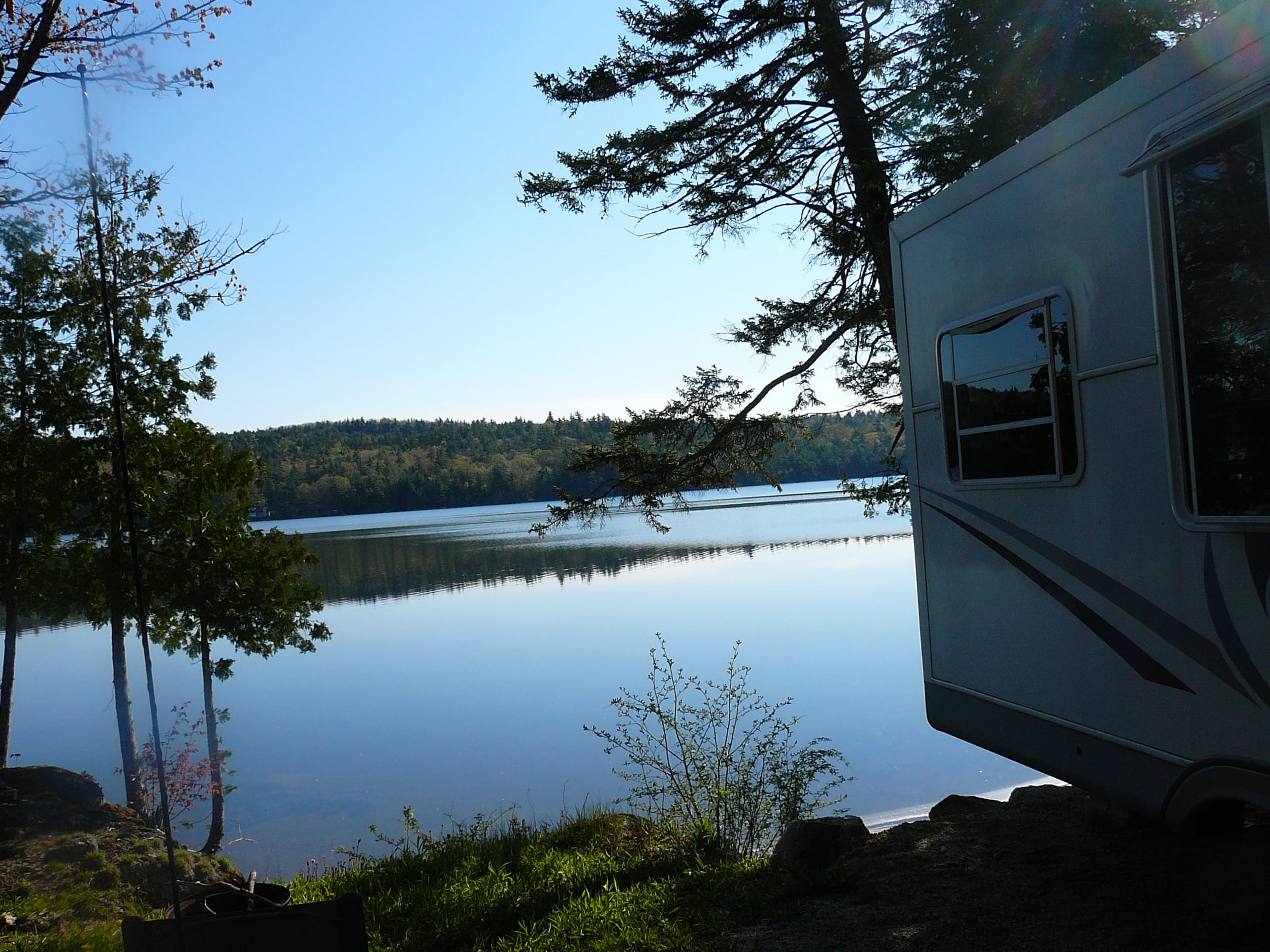 A white rv parked next to the water.
