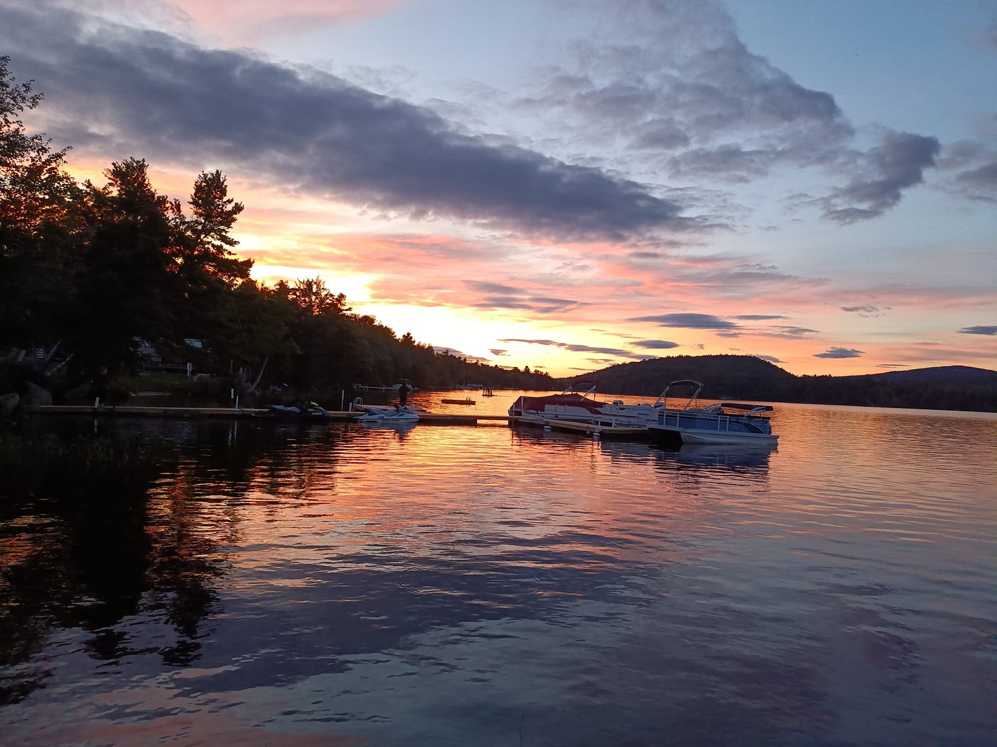 A boat is in the water at sunset.
