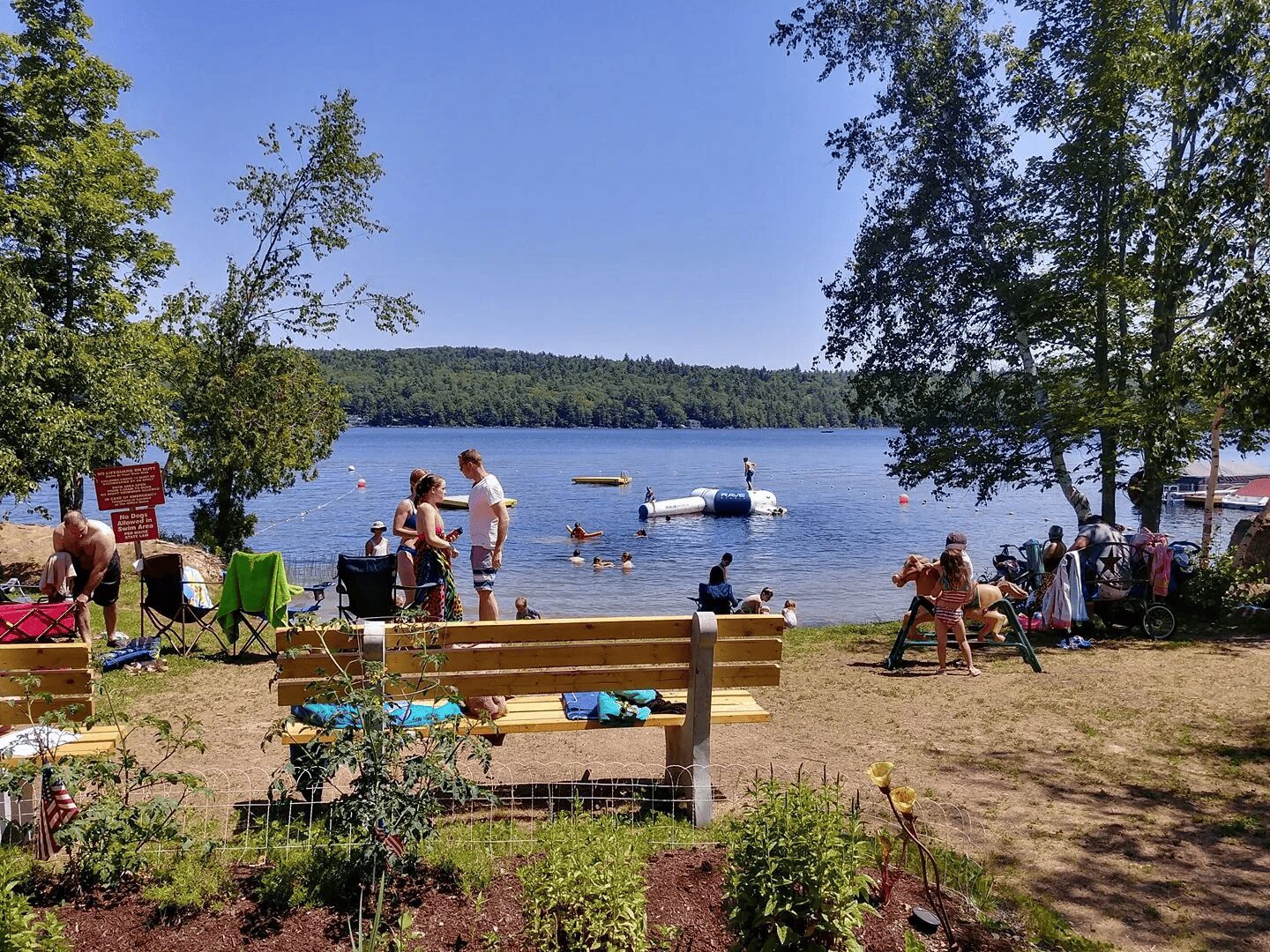 A group of people standing around by the water.