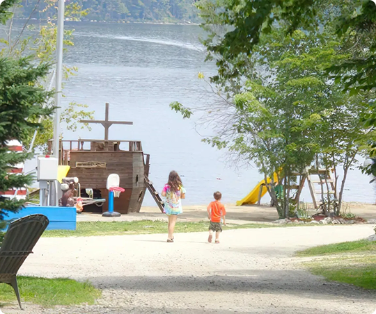Children walking toward a lake and playground.